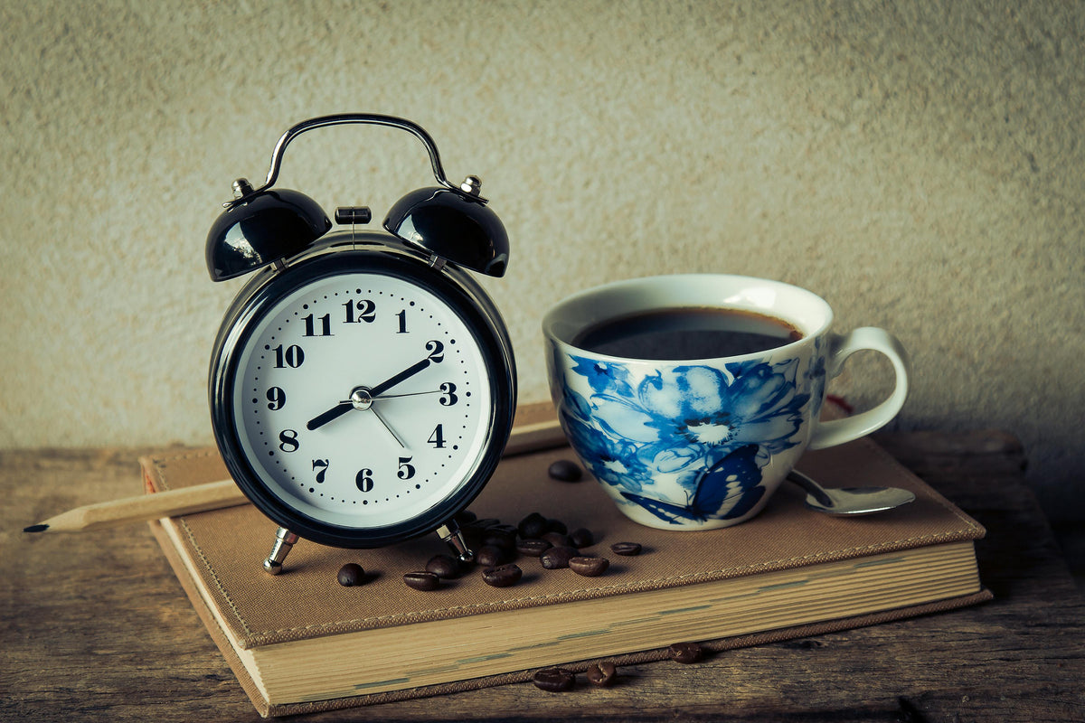 Keto intermittent fasting concept with a cup of coffee and clock on table symbolizing morning fasting routine