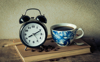 Keto intermittent fasting concept with a cup of coffee and clock on table symbolizing morning fasting routine