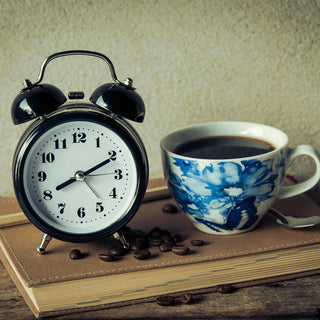Keto intermittent fasting concept with a cup of coffee and clock on table symbolizing morning fasting routine